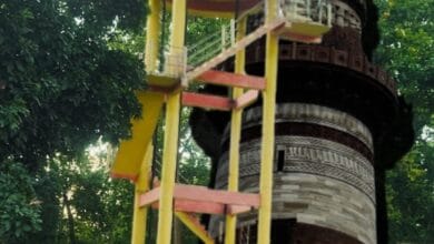 कोदोभाट में जल जीवन मिशन योजना का सूचना बोर्ड और क़ुतुब मीनार की प्रतिबिम्ब वाली प्रतीकात्मक तस्वीर